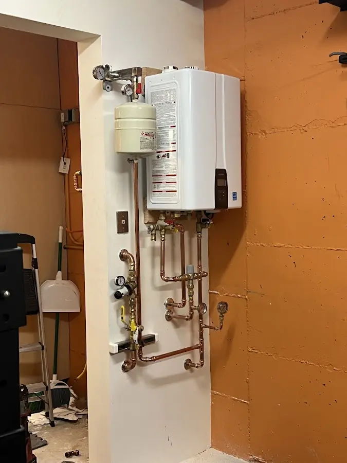 Plumbing technician inspecting water heater connections in Green Brook